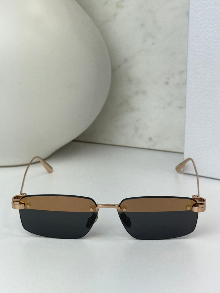 Rimless sunglasses with dark rectangular lenses and thin gold-tone rims