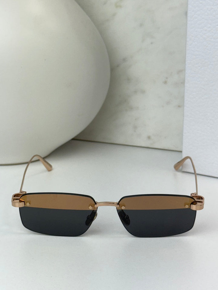 Rimless sunglasses with dark rectangular lenses and thin gold-tone rims