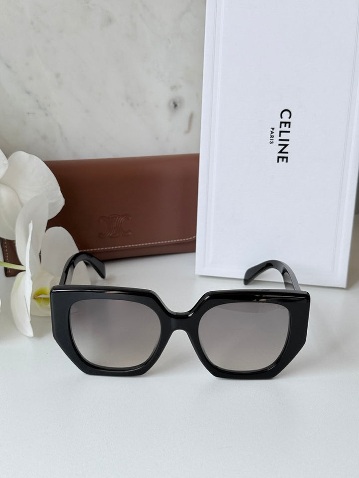 Celine black squared cat-eye sunglasses next to white Celine case and box