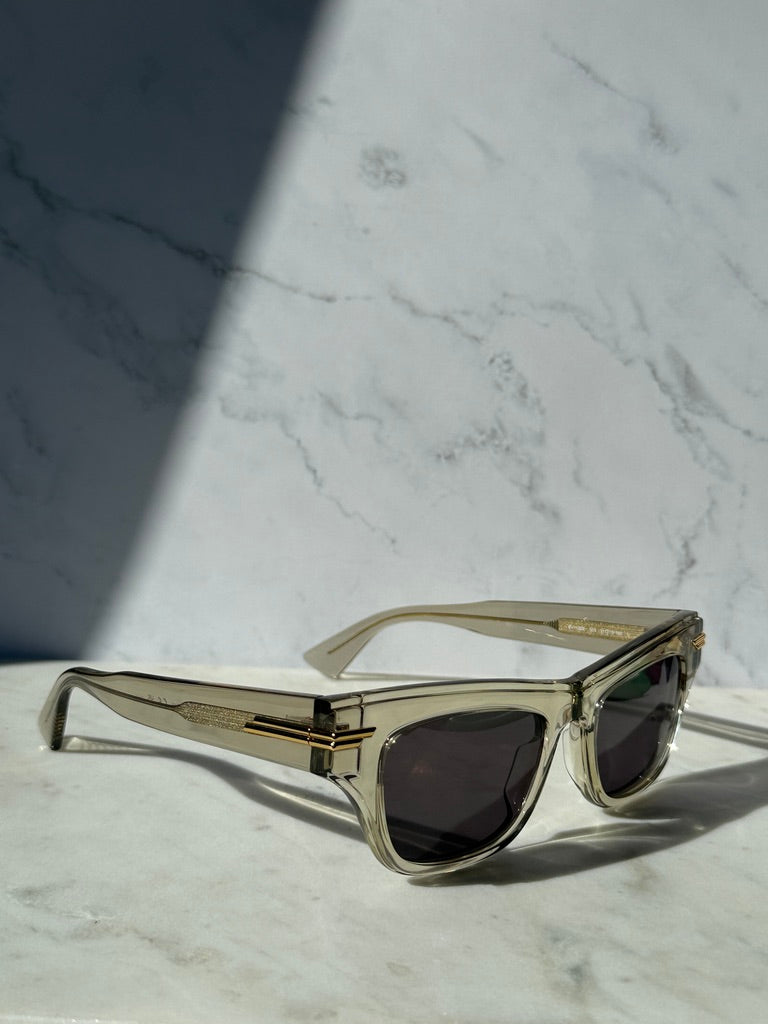 Mitre rectangular sunglasses with clear frame and dark lenses, gold metal details