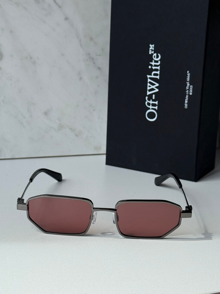 Gunmetal Loa sunglasses with burgundy lenses, shown with Off White case behind