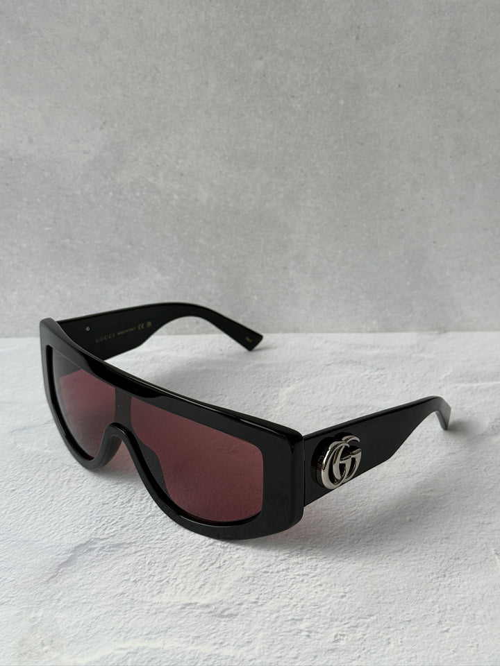 Shield sunglasses with black frame, maroon-tinted lenses, GG logo on temple