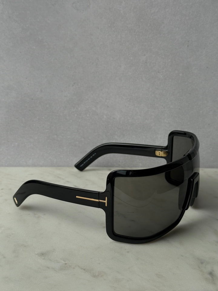 Black mask-style sunglasses with oversized lenses and gold logo details