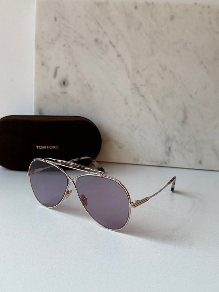 Gold aviator sunglasses with purple lenses and tortoise temple tips, with case