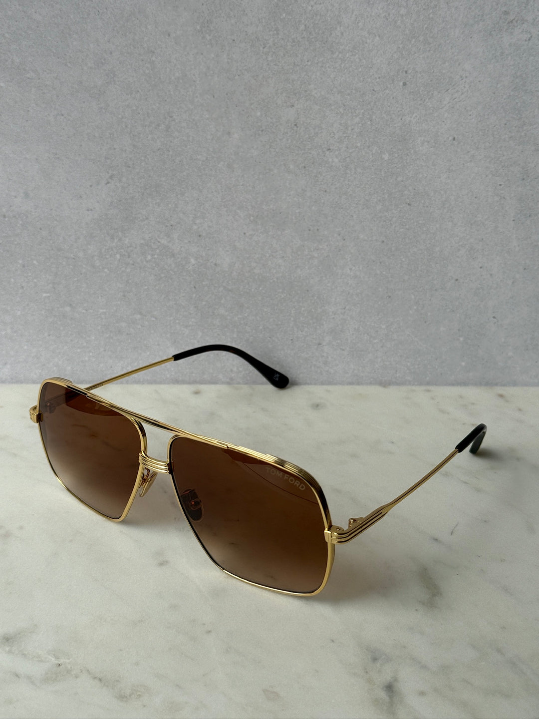 Gold-tone aviator sunglasses with dark brown lenses and black temples