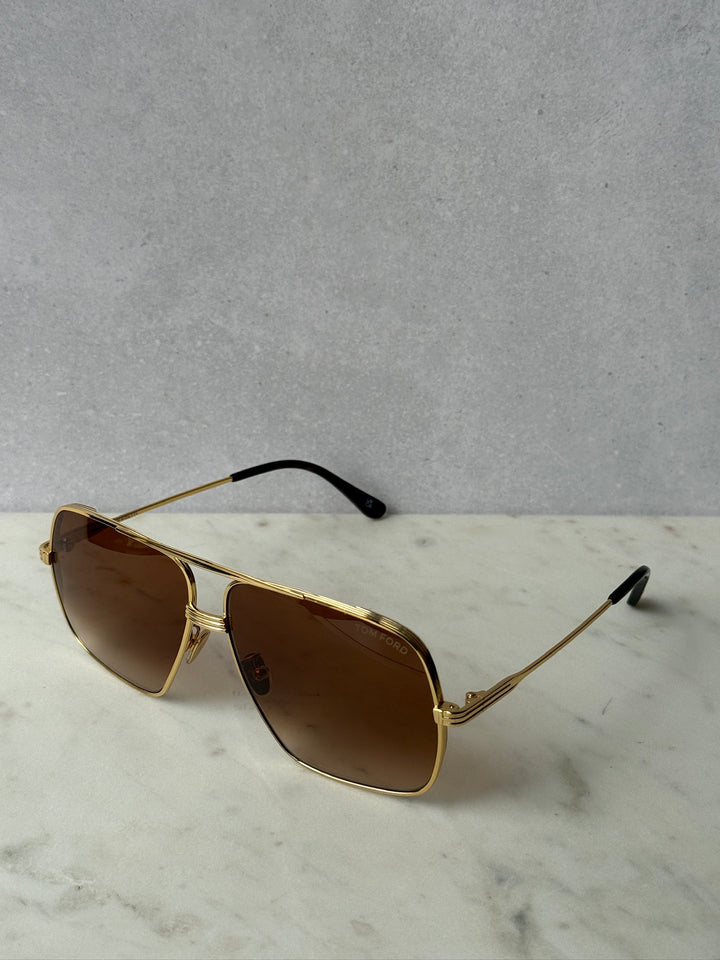 Gold-tone aviator sunglasses with dark brown lenses and black temples