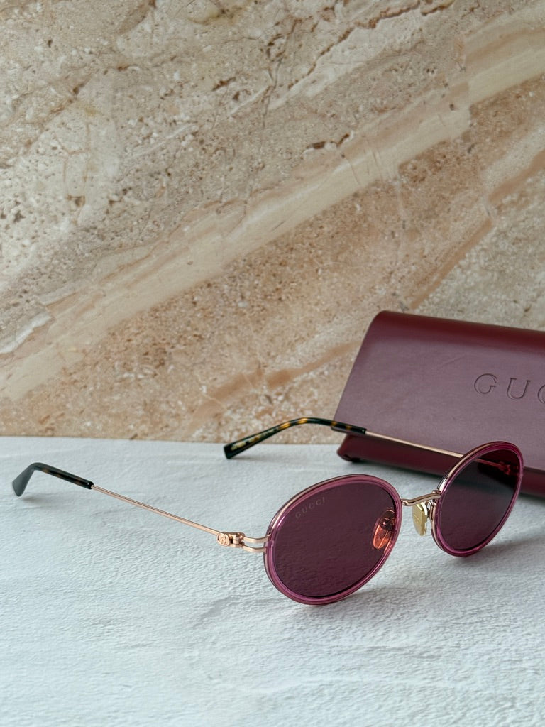 Gucci oval pink sunglasses with dark lenses and pink case with Gucci logo