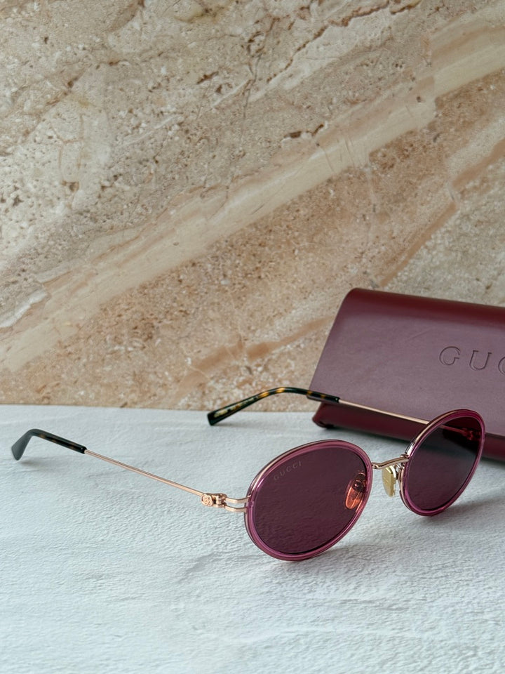 Gucci oval pink sunglasses with dark lenses and pink case with Gucci logo
