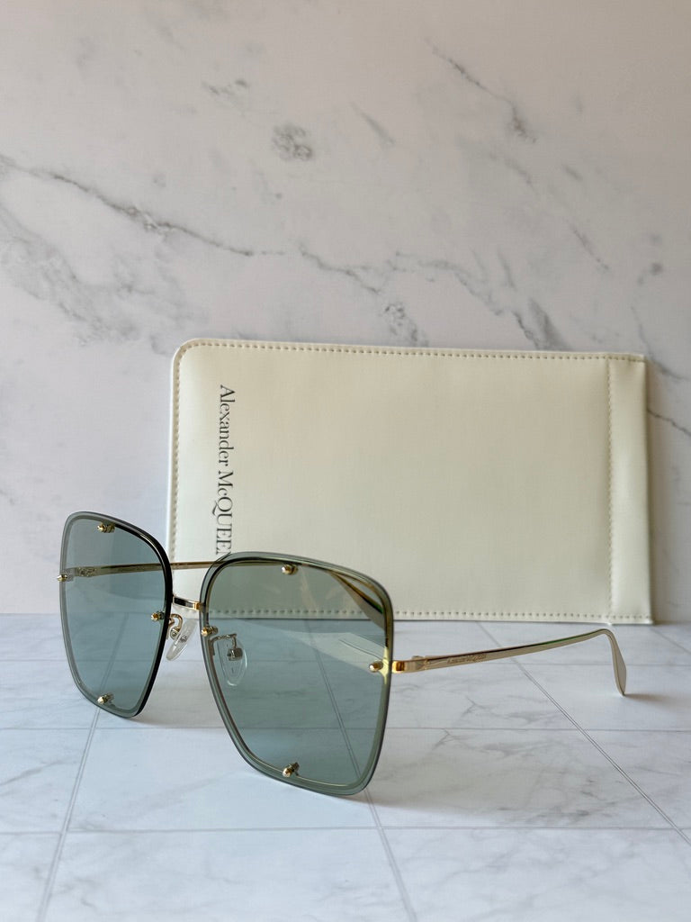 Oversized square sunglasses with green lenses and slim gold side arms