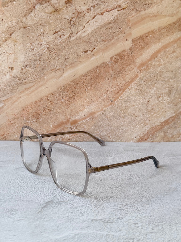 Gucci transparent grey square eyeglass frames, side profile with gold-tone arm