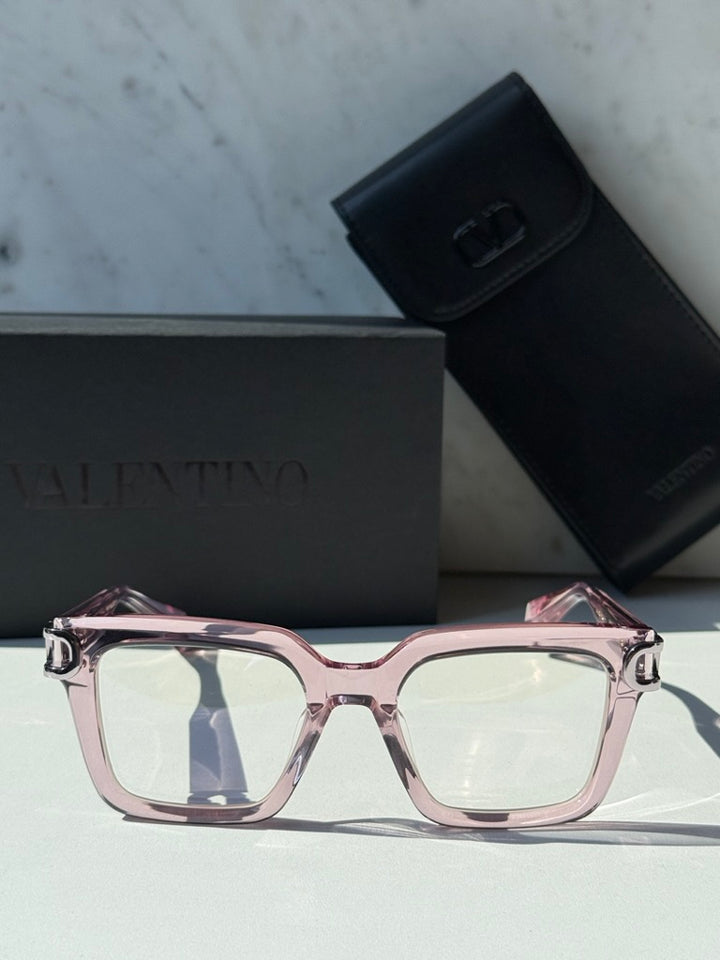 Pink square eyeglasses with clear lenses and chrome V logo at center