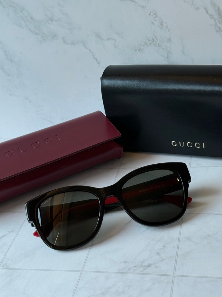 Gucci GG1866SK black sunglasses with dark lenses and red-green striped temples