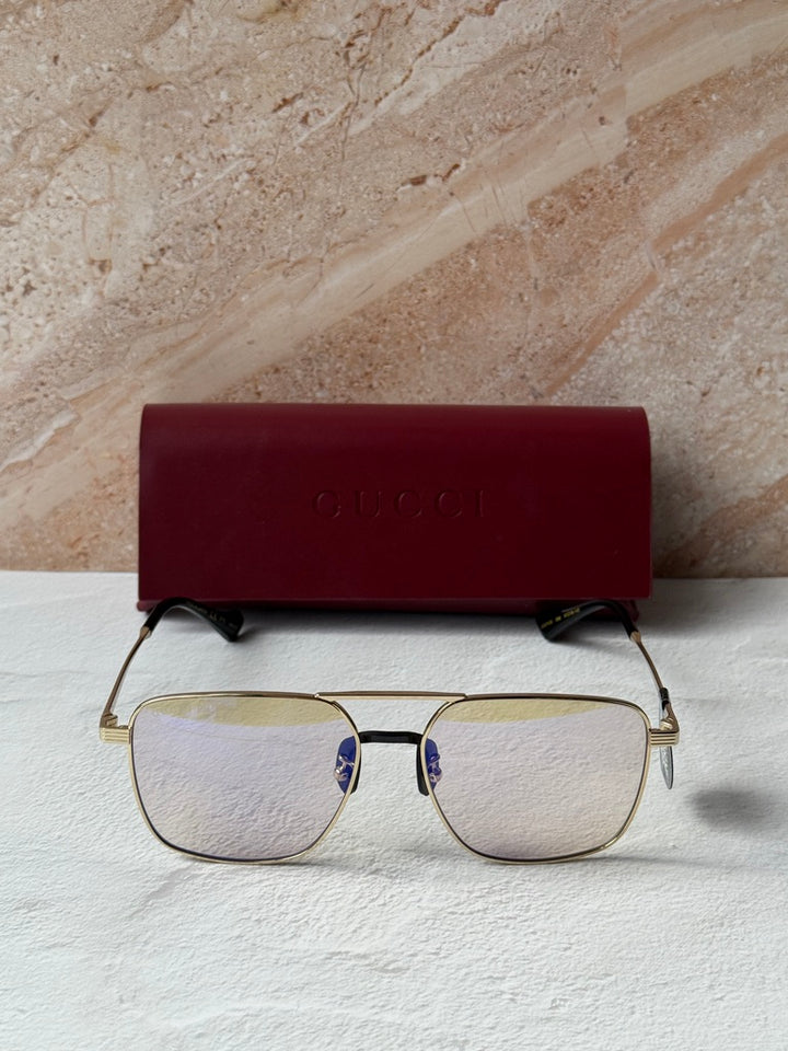 Gucci gold metal pilot sunglasses with photochromic lenses and black nose bridge accents