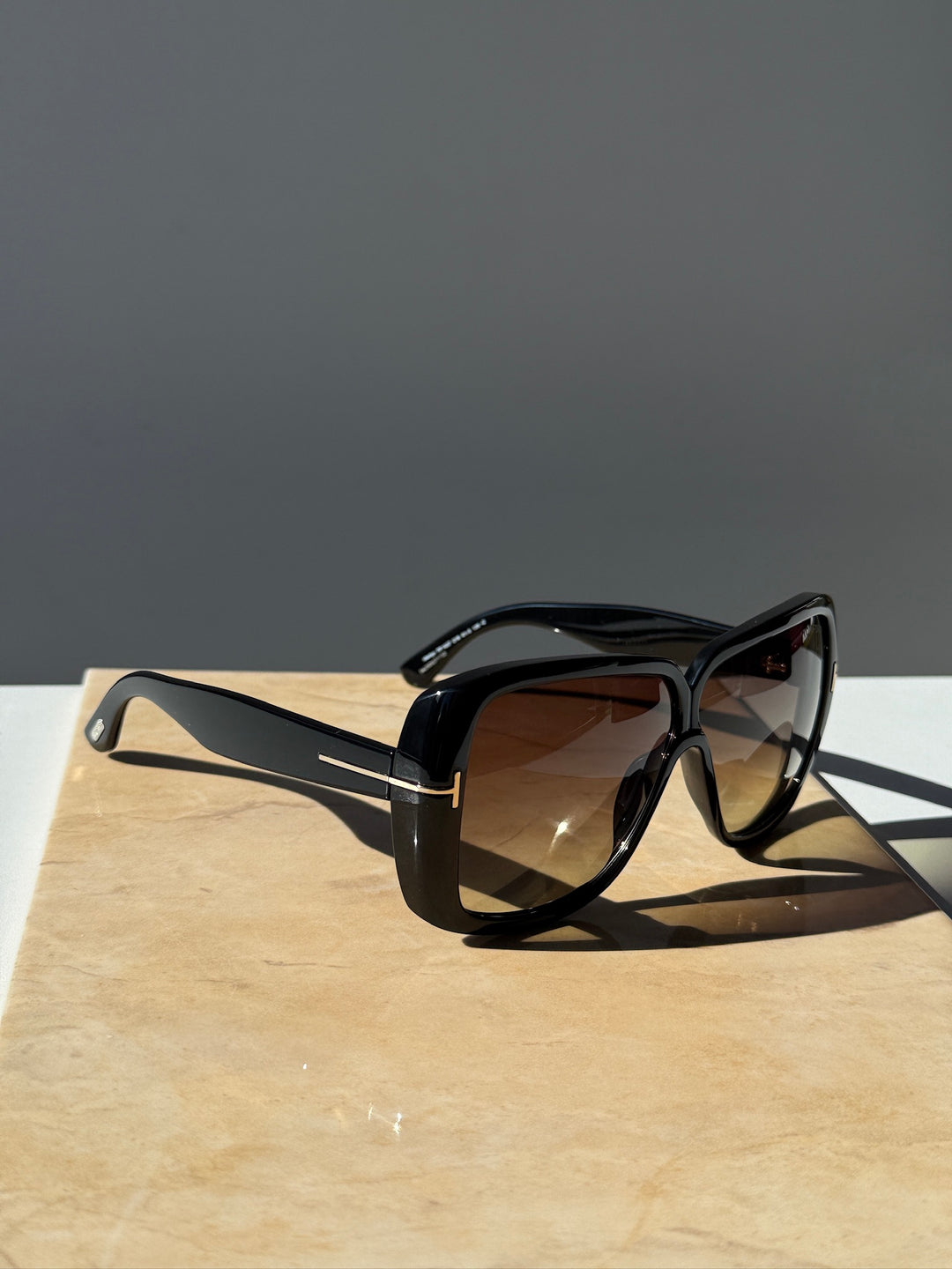Black square sunglasses side view with brown-tinted lenses and thick frame