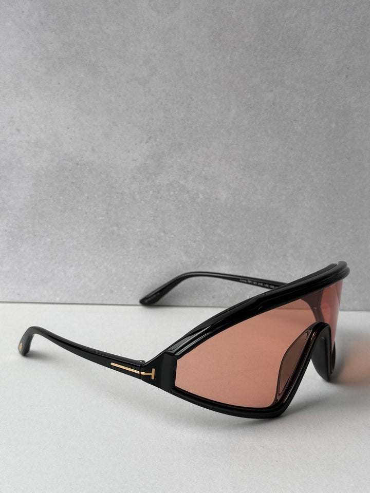 Black sunglasses with orange-tinted lenses, angled side view