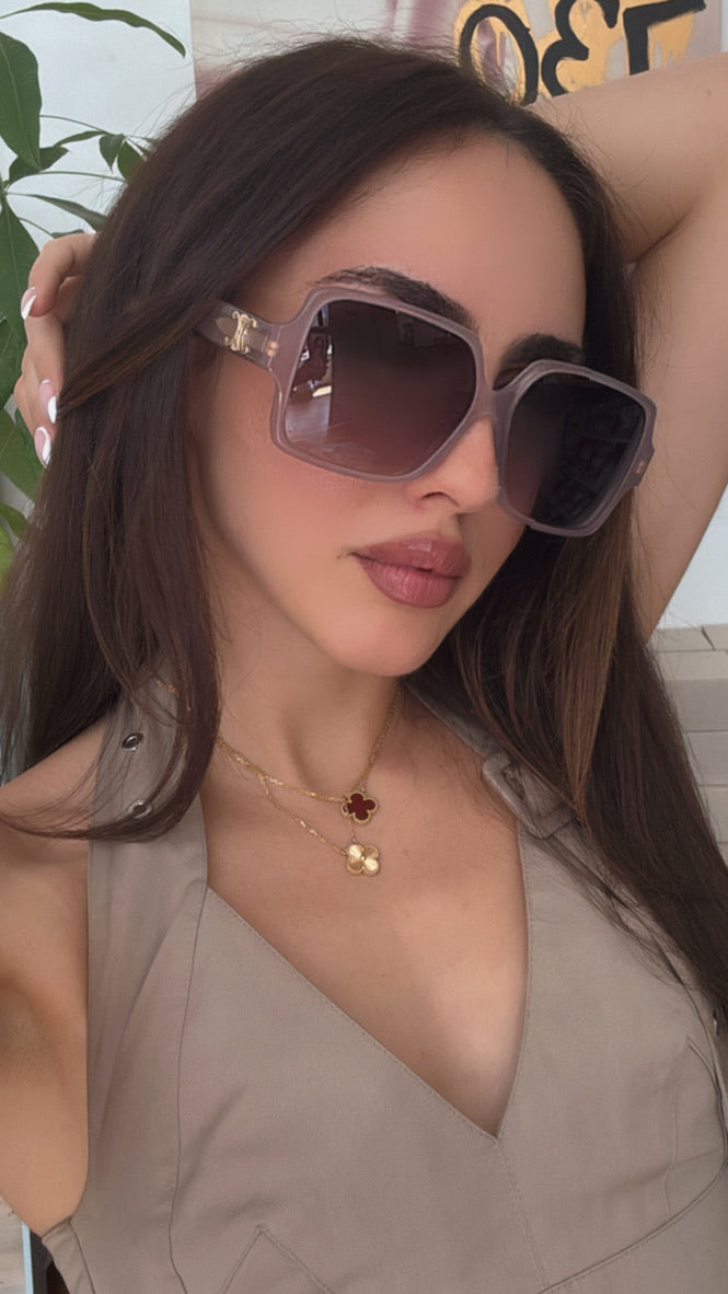 Taupe square sunglasses worn on face, dark tinted lenses, gold logo temple detail