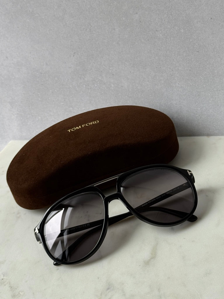 Black oversized aviator sunglasses with dark lenses and brown case