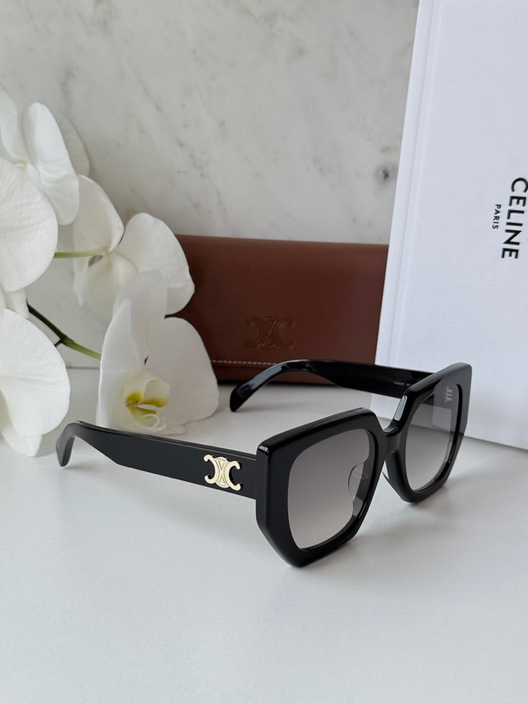 Celine black squared cat-eye sunglasses with gold temple logo on display surface