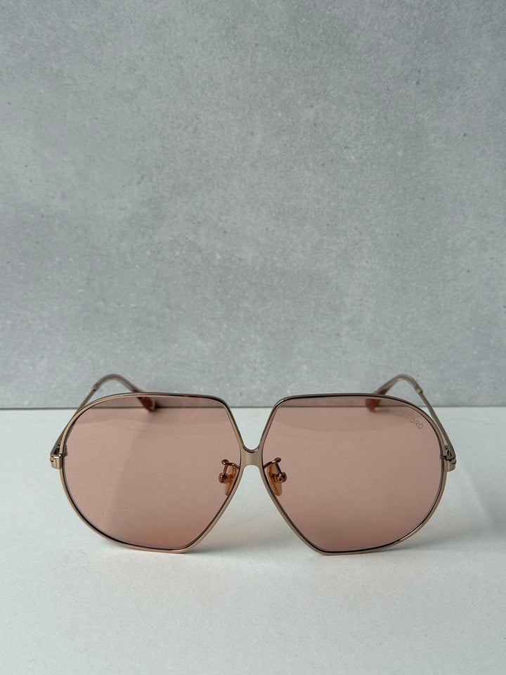 Rose gold oversized sunglasses with symmetrical rose-tinted lenses and metal nose bridge