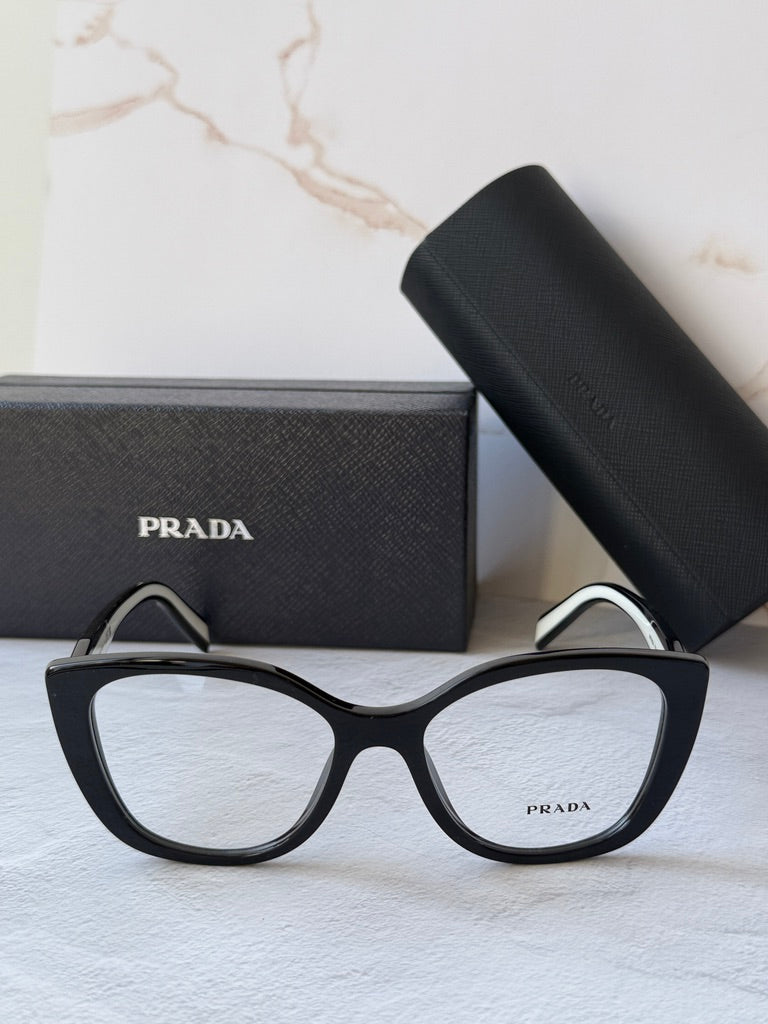 Black cat-eye eyeglasses frames with clear lenses and Prada-branded temple tips.
