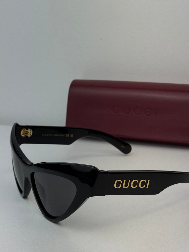 Gucci black cat-eye sunglasses with dark lenses and Gucci branding on temple