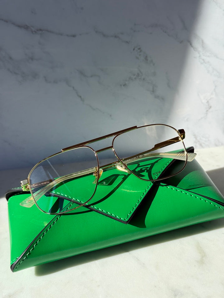Gold pilot eyeglass frames with clear lenses and slim metal rims
