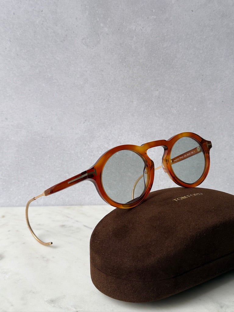 Round brown tortoise sunglasses with gold-tone metal arms and slim bridge