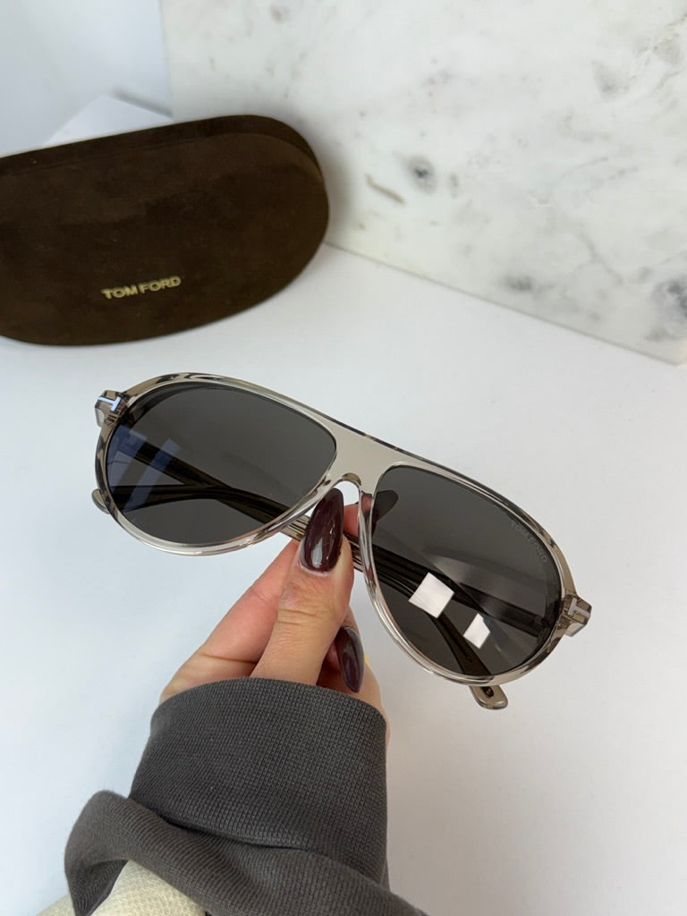 Aviator sunglasses with dark lenses and silver frame, close-up in hand