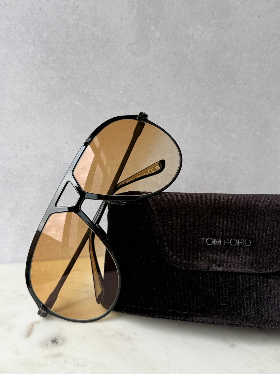 Oversized black aviator sunglasses with amber tinted lenses, with black fabric case