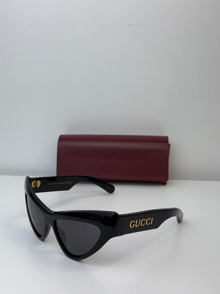 Gucci black cat-eye sunglasses with dark lenses and burgundy case