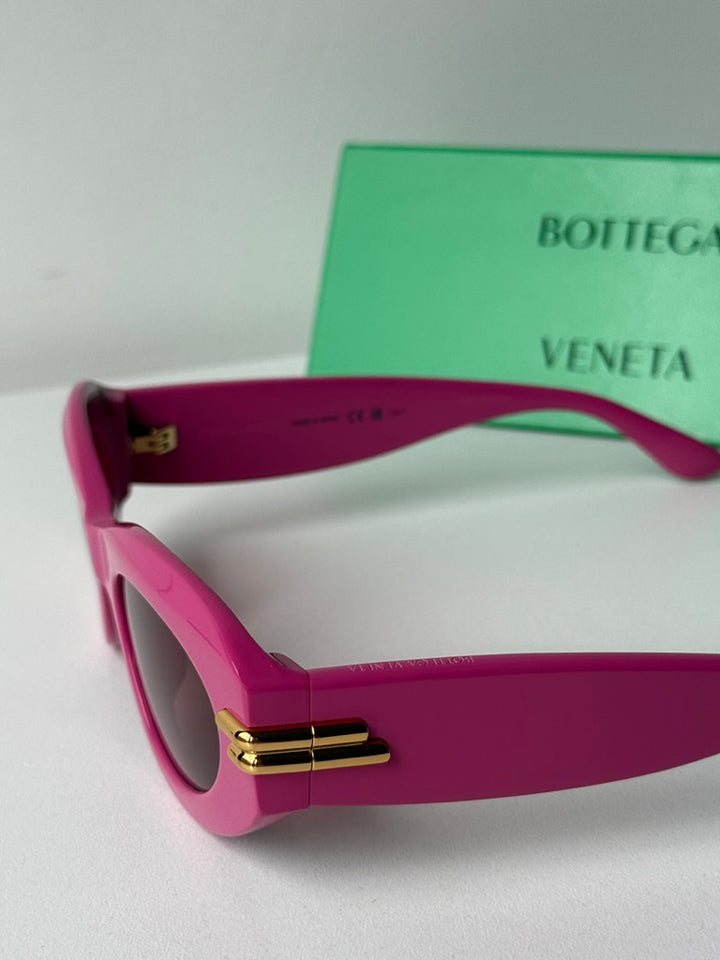 Pink sunglasses close-up of gold hinge and dark lens frame