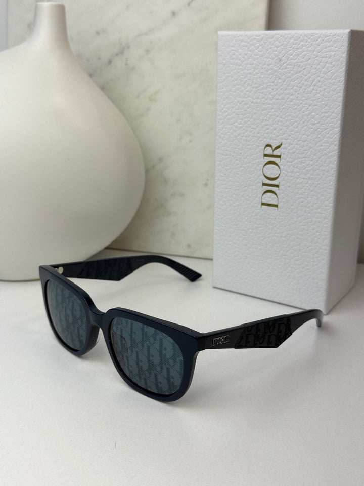 Navy Dior sunglasses with dark mirror lenses and branded temple, resting on display.