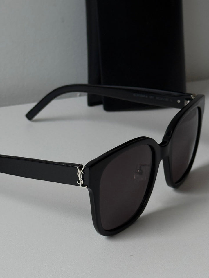 Saint Laurent black cat-eye sunglasses side view with dark lenses and metal hinge
