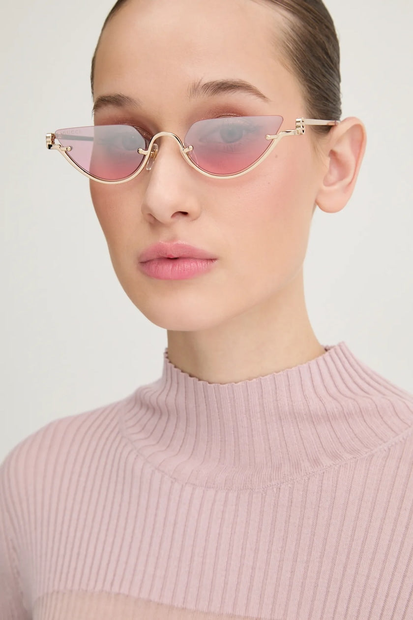 Gucci half-rim sunglasses on model, gold frame with pink lenses