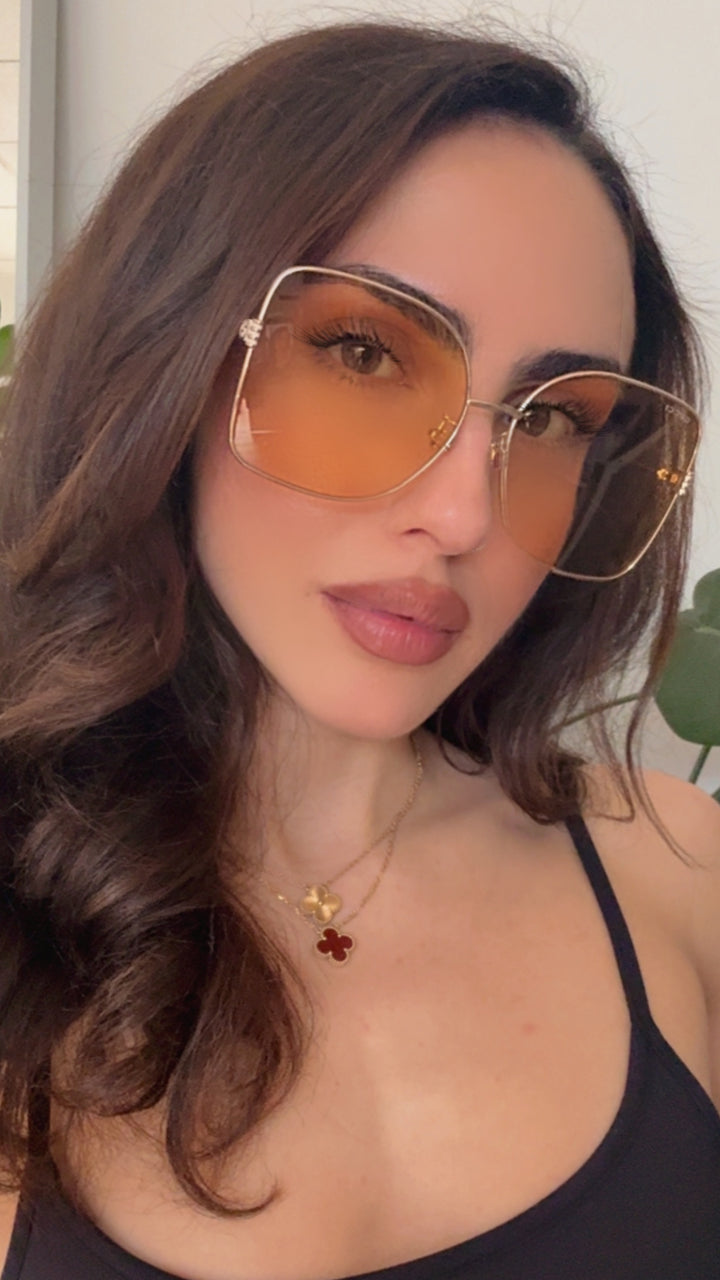 Gucci gold-tone square sunglasses with amber tinted lenses on face