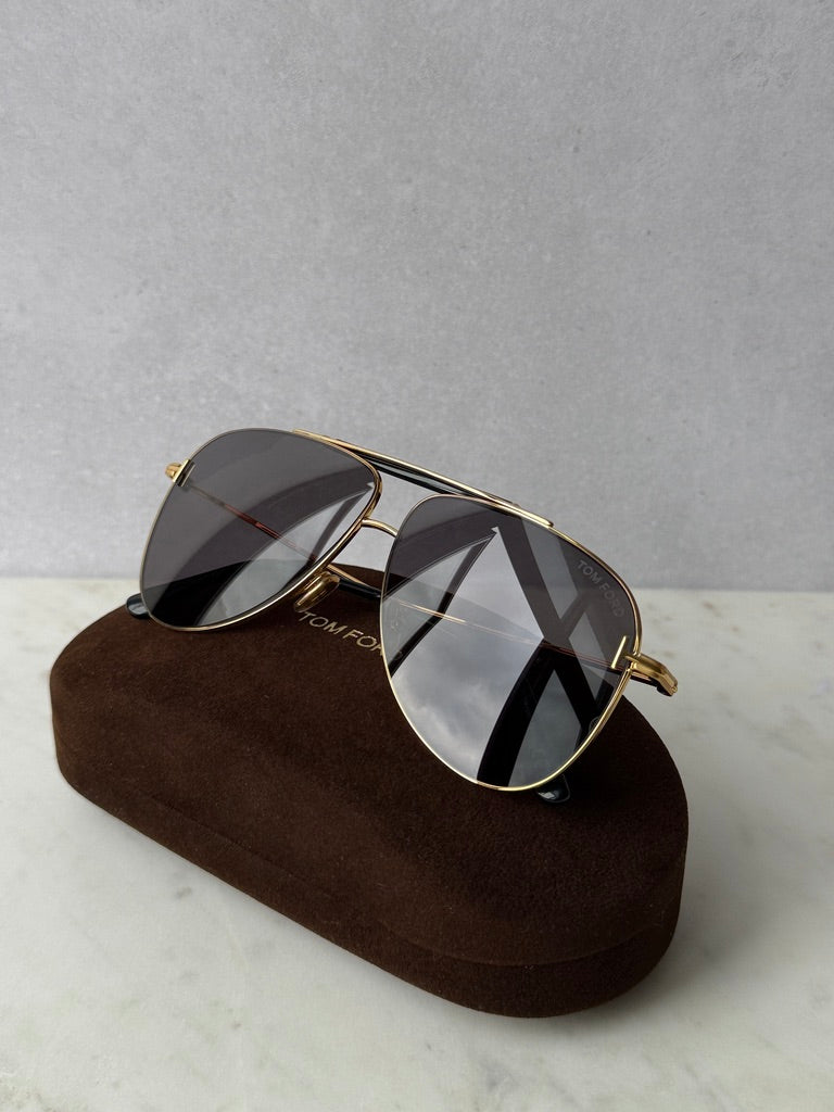 Gold aviator sunglasses with dark lenses, side view with brown case