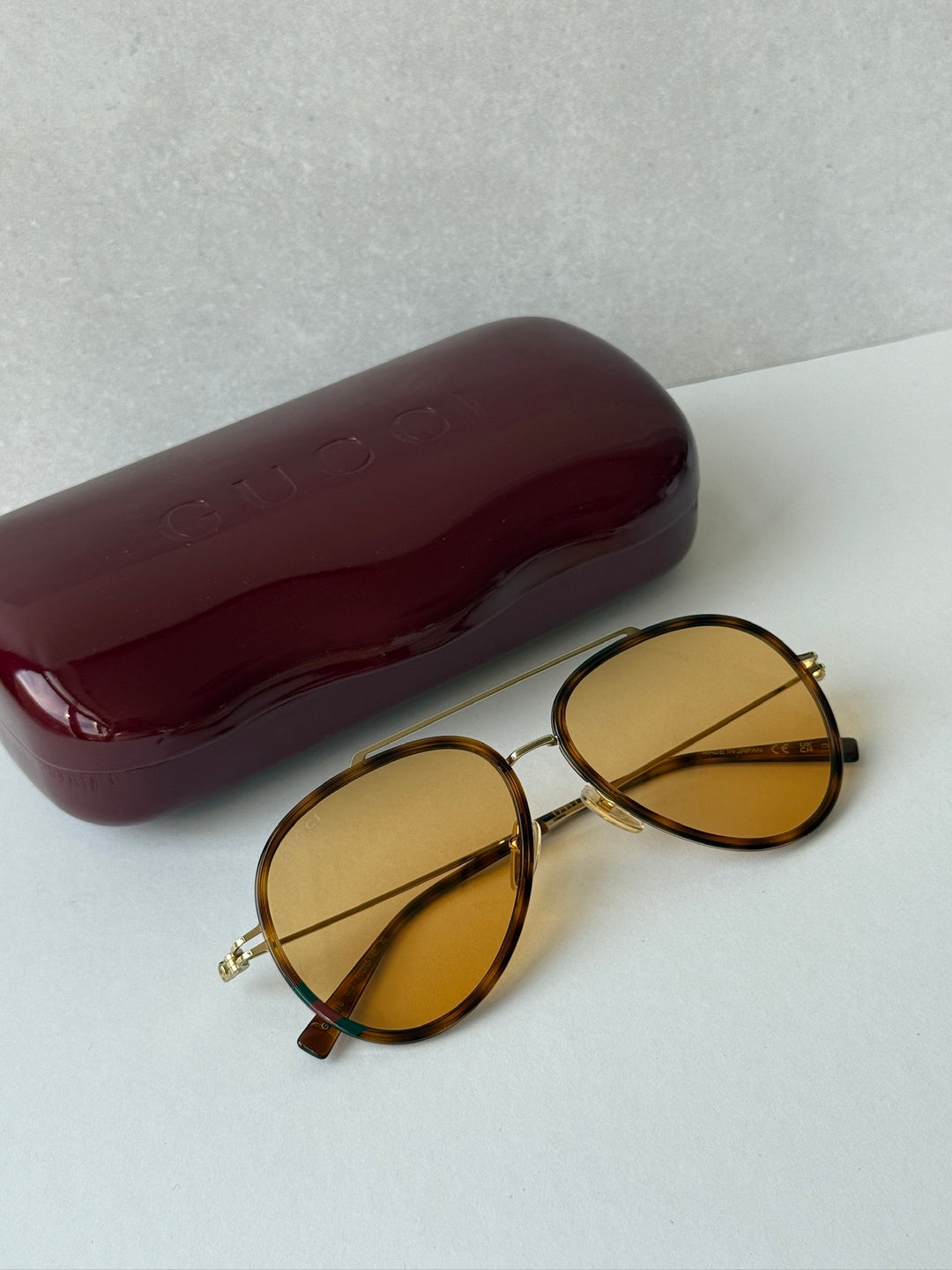 Gucci aviator sunglasses with oval brown frames and amber tinted lenses, gold accents
