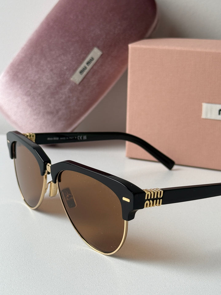 Miu Miu black cat-eye sunglasses close-up with brown lenses and gold hinge detail