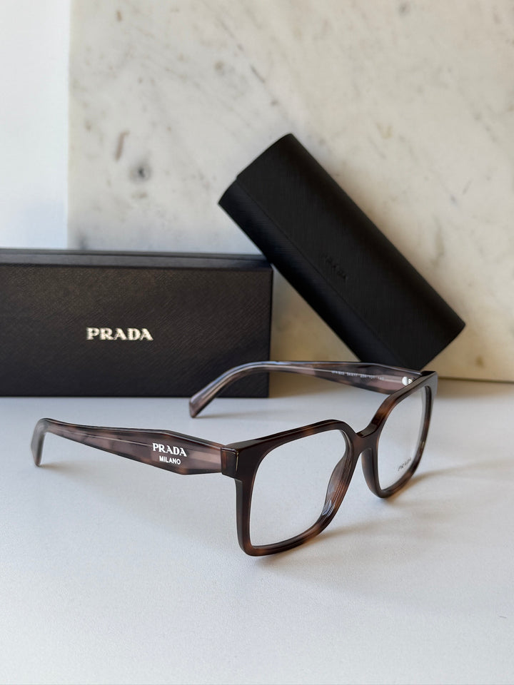 Prada eyeglass frames in mauve tortoise with clear lenses, angled view