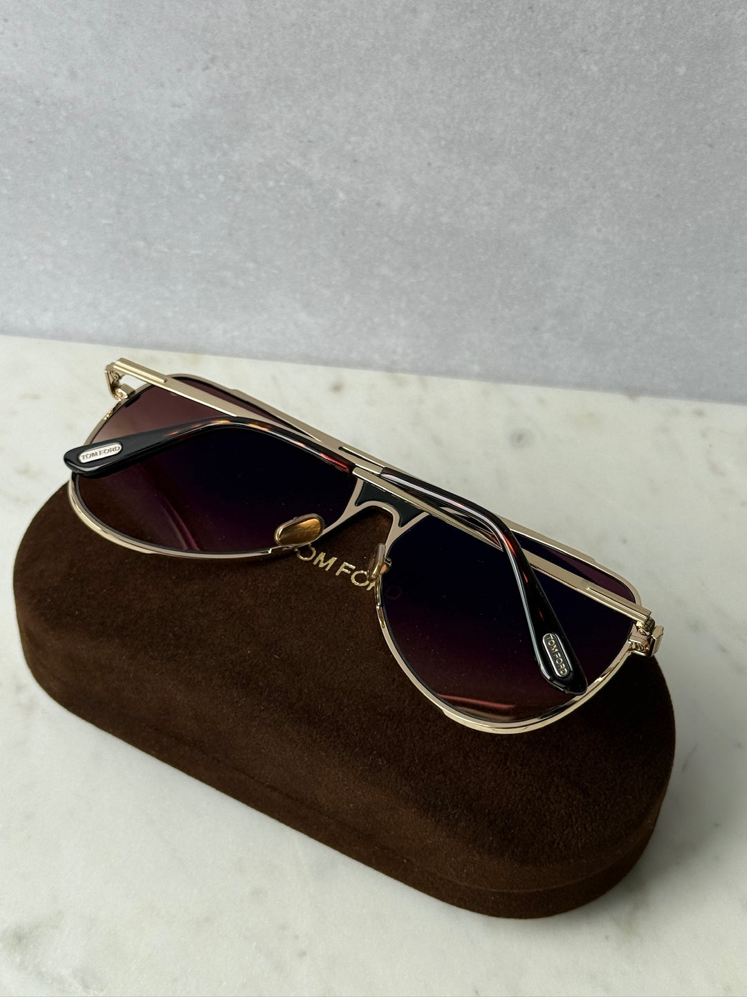 Rose gold pilot sunglasses, side view with dark tinted lenses and temple details