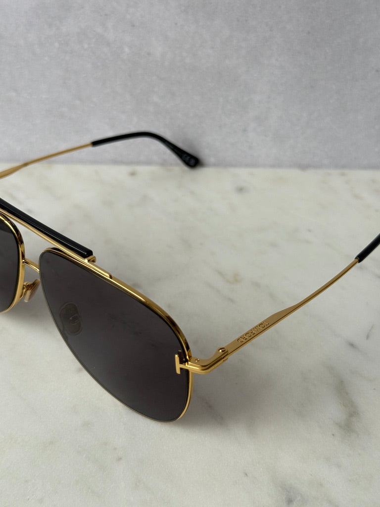 Gold aviator sunglasses close-up of dark lenses and gold bridge