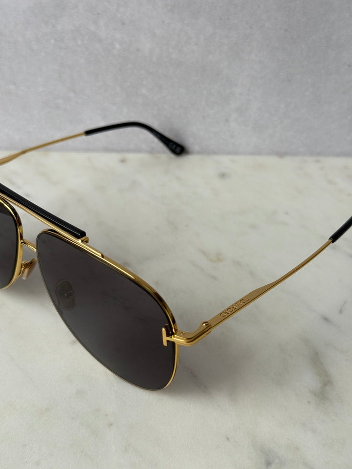 Gold aviator sunglasses close-up of dark lenses and gold bridge