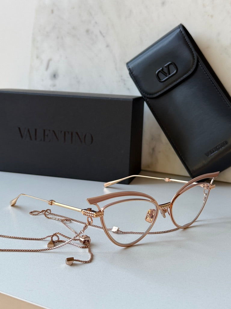 Gold-tone cat-eye eyeglass frames with beige lenses and chain necklace accessory