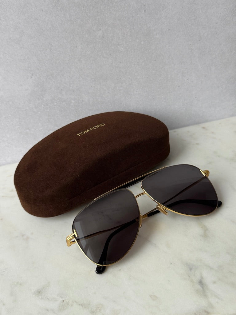 Gold aviator sunglasses with dark lenses and a brown hard case
