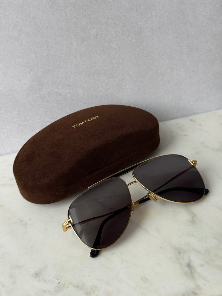 Gold aviator sunglasses with dark lenses and a brown hard case