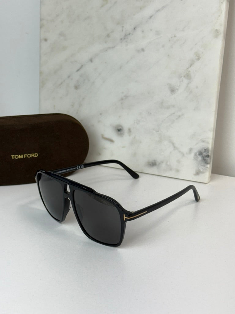 Black Tom Ford sunglasses with dark lenses and slim black frame arms.