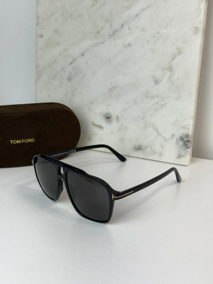 Black Tom Ford sunglasses with dark lenses and slim black frame arms.