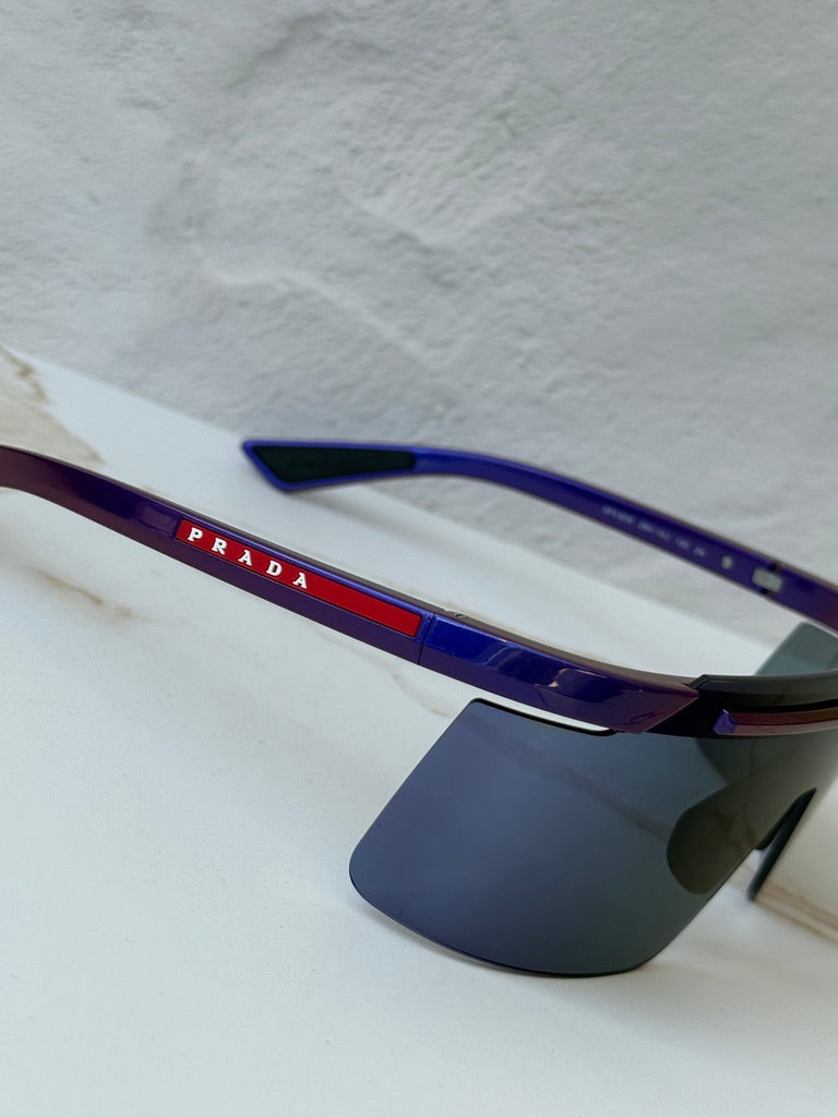 Prada Sport PS sunglasses close-up: purple frame with dark mirrored shield lenses