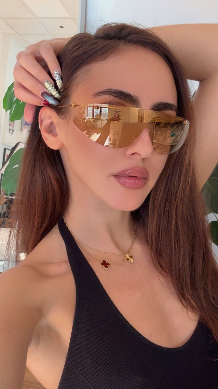 Gold knot shield sunglasses with mirrored lenses, slim gold frame