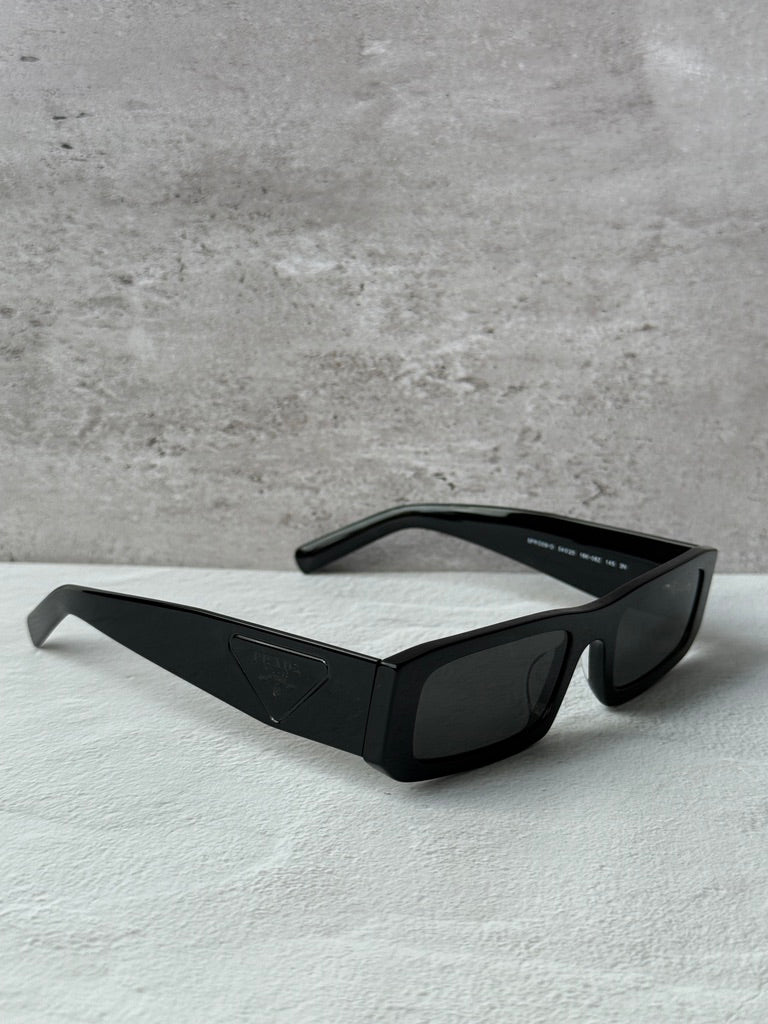 Prada black rectangular sunglasses with dark lenses, angled top view.